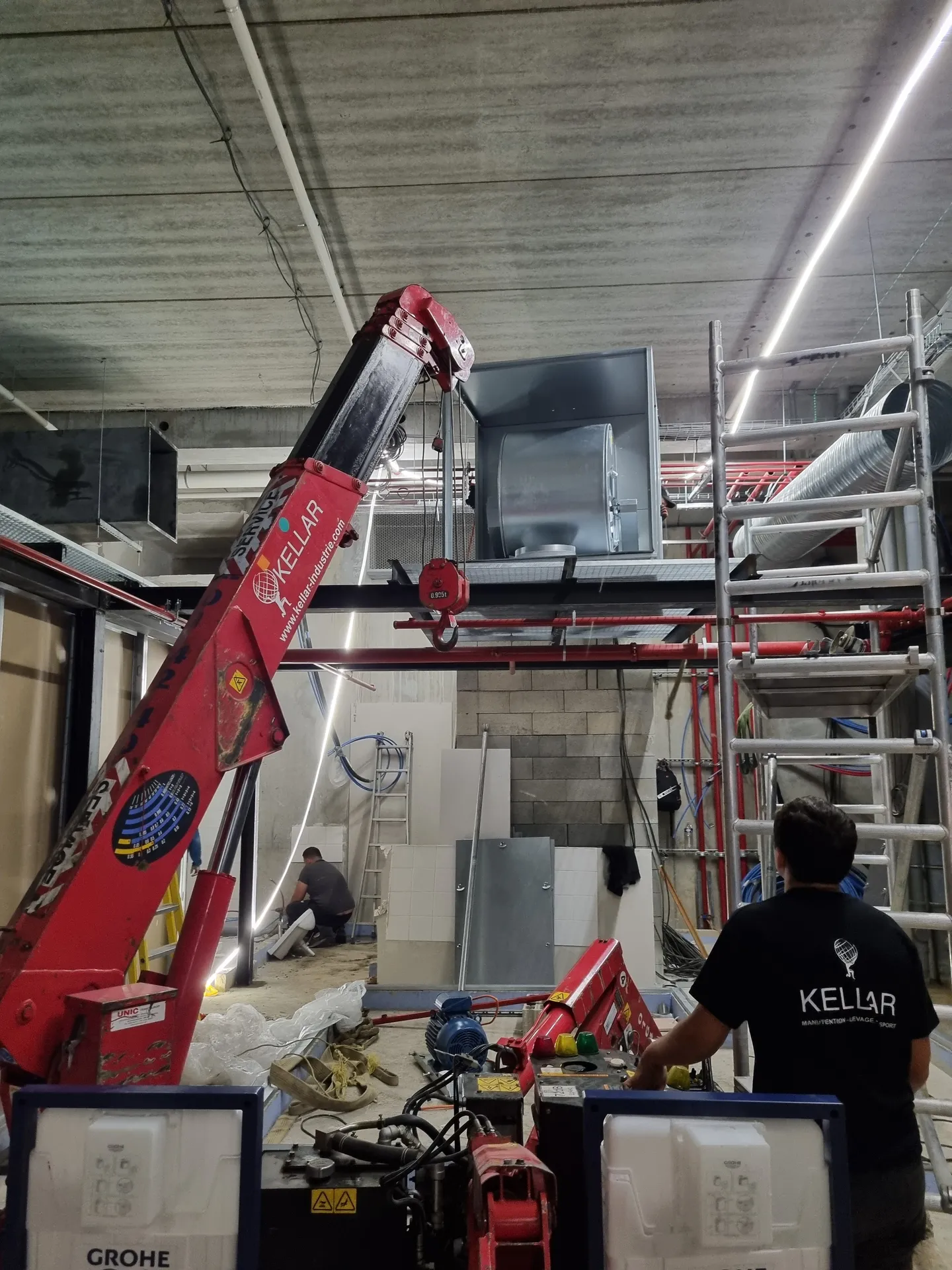 Mise en place d'un caisson d'extraction à la grue araignée sur une mezzanine