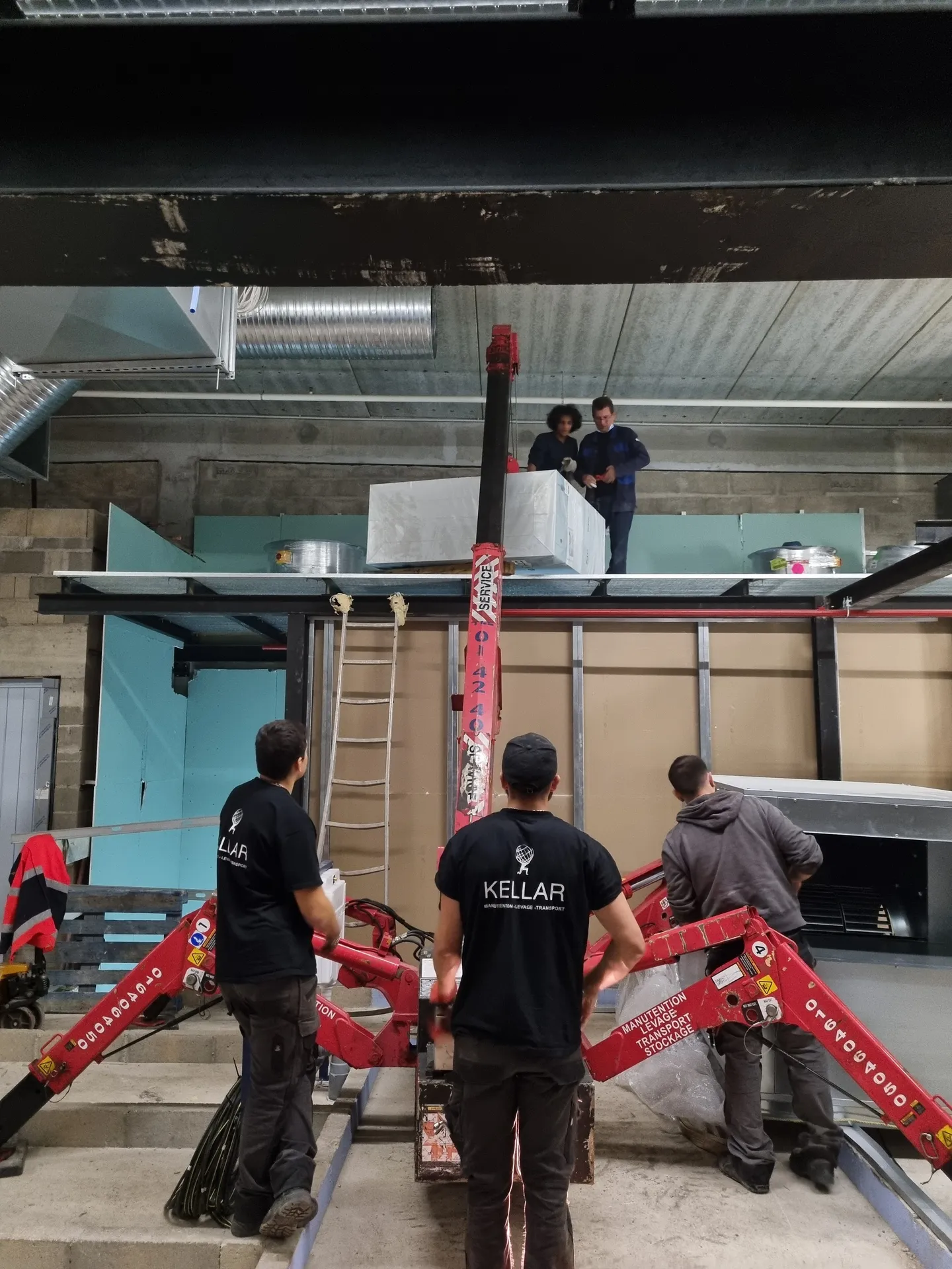 Mise en place d'un caisson d'extraction à la grue araignée sur une mezzanine
