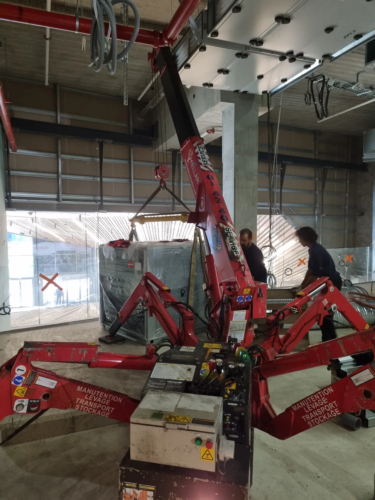 Mise en place d'un caisson d'extraction à la grue araignée sur une mezzanine
